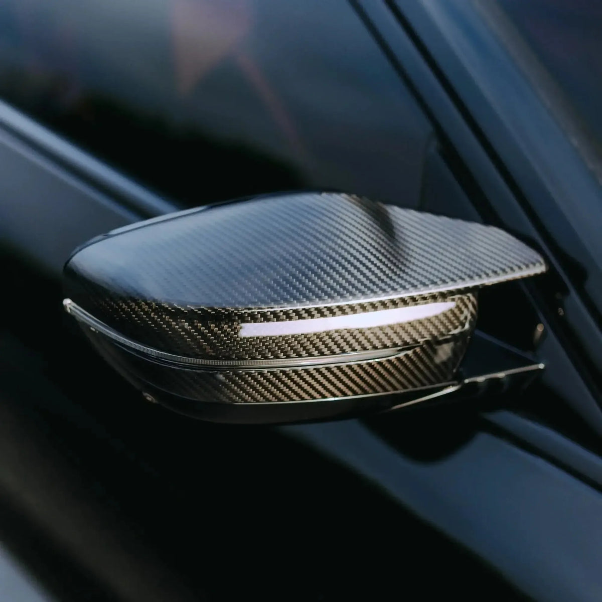 Close-up of the carbon mirror cap on a black BMW G20, front three-quarter view (M Style)