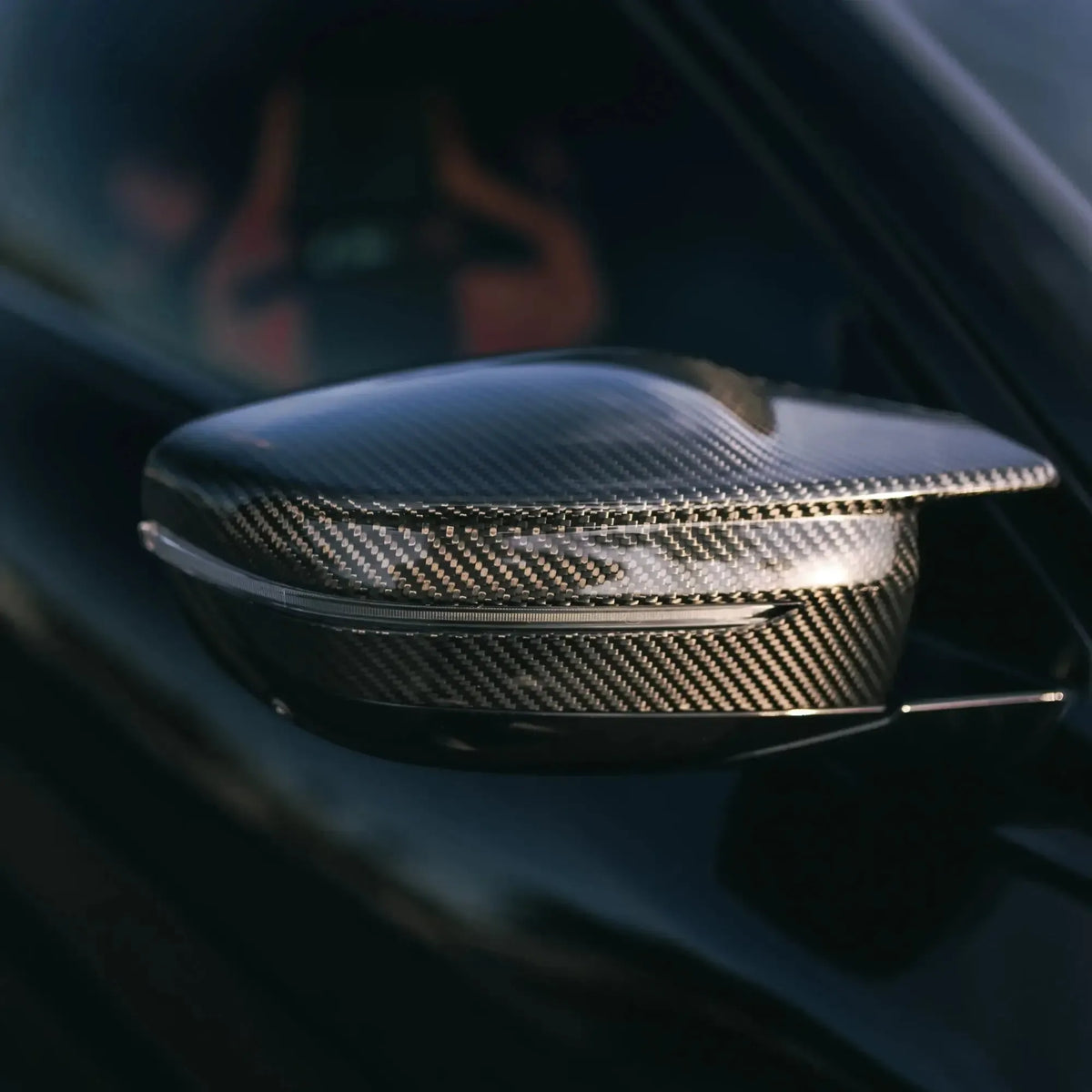 Carbon mirror cap fitted to a black BMW G20, close-up side view (M Style)