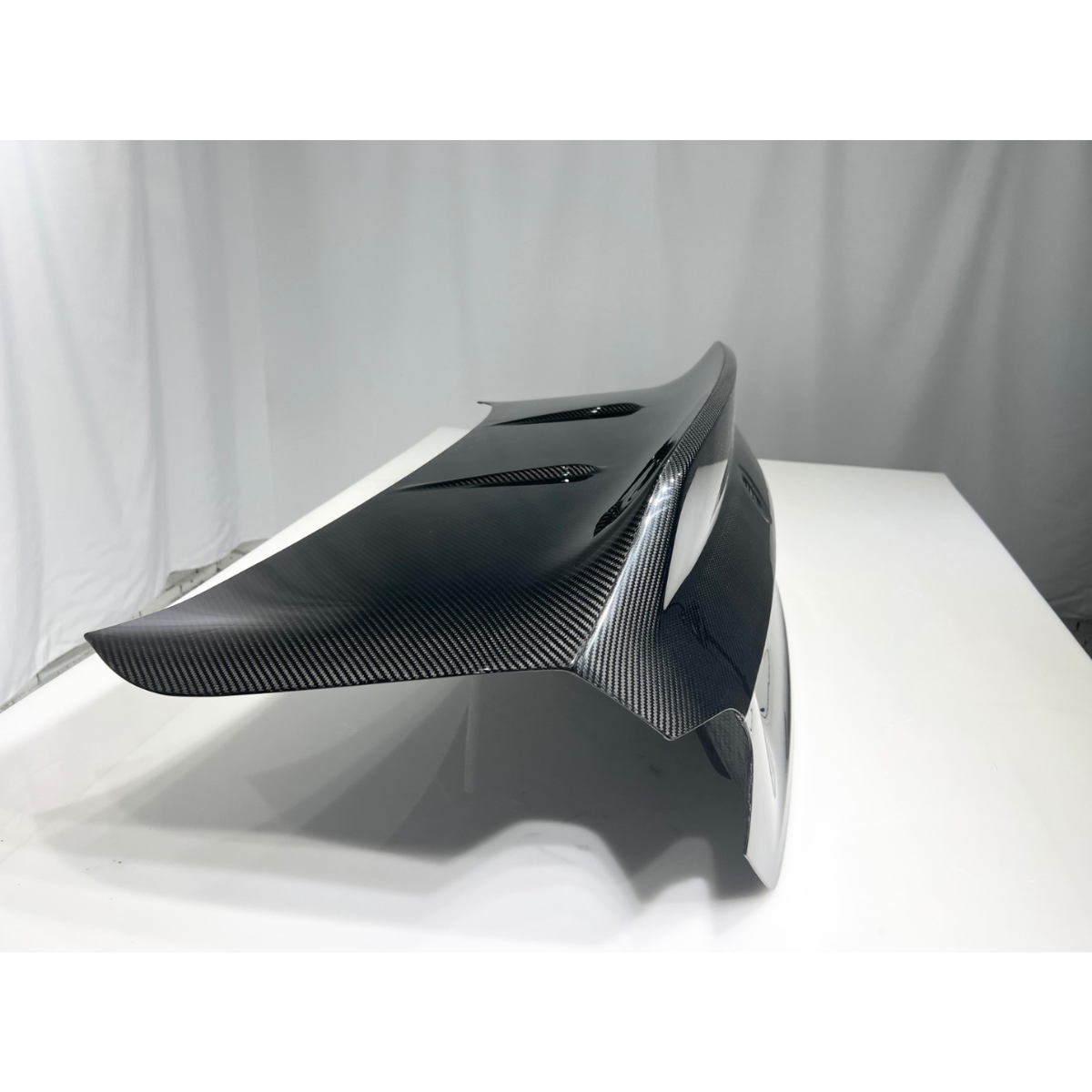 Carbon fiber trunk lid, side three-quarter view, on a white table (CS Style) – BMW G87 M2
