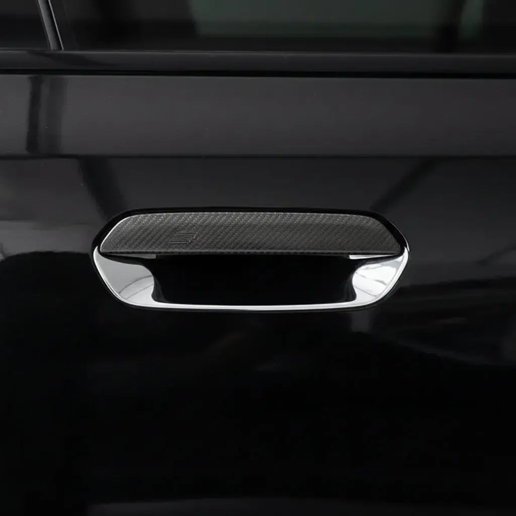 Fekete BMW G87 M2 ajtókilincse közelről, felszerelt carbon kilincsborítással