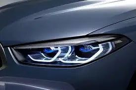 A sötétszürke bmw retrofit fényszóró a g szériához éles led világítással és kék részletekkel modern designban a kipufogó rendszer mellé