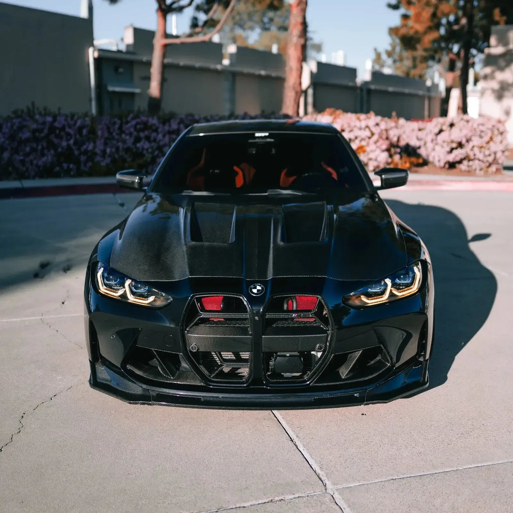 Black BMW G82 M4 from the front, with red Front mount intake filters behind the grille