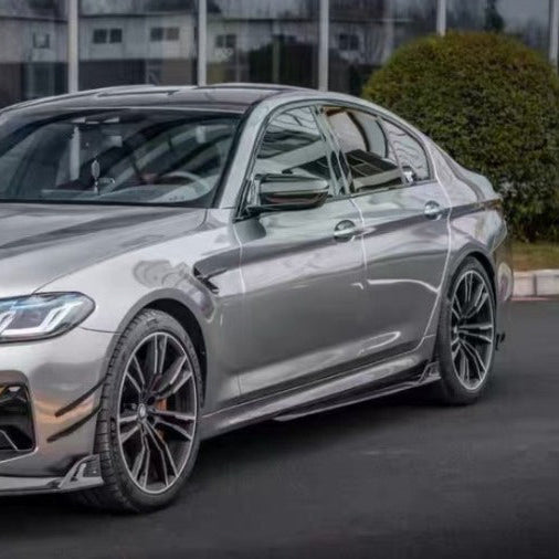 Gray BMW F90 M5 LCI three-quarter side view, with carbon side skirts, canards and front lip (Track Style)
