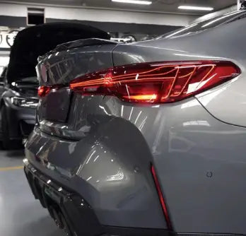 A csl laser hátsó lámpa a bmw m4 hátsó részén piros ledekkel és sportos karbon fiber kipufogó rendszerrel