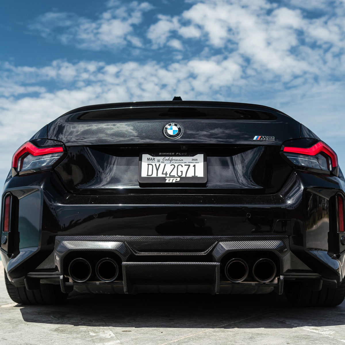 Rear of a black BMW G87 M2 with carbon fiber rear diffuser (AN Style)
