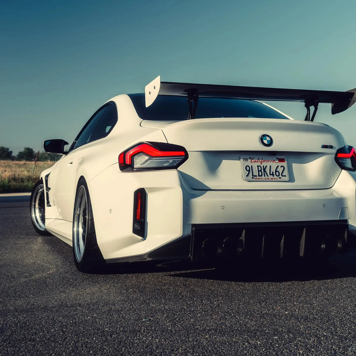 Rear of a white BMW G87 M2 with carbon fiber rear diffuser (Signature V1 Style)