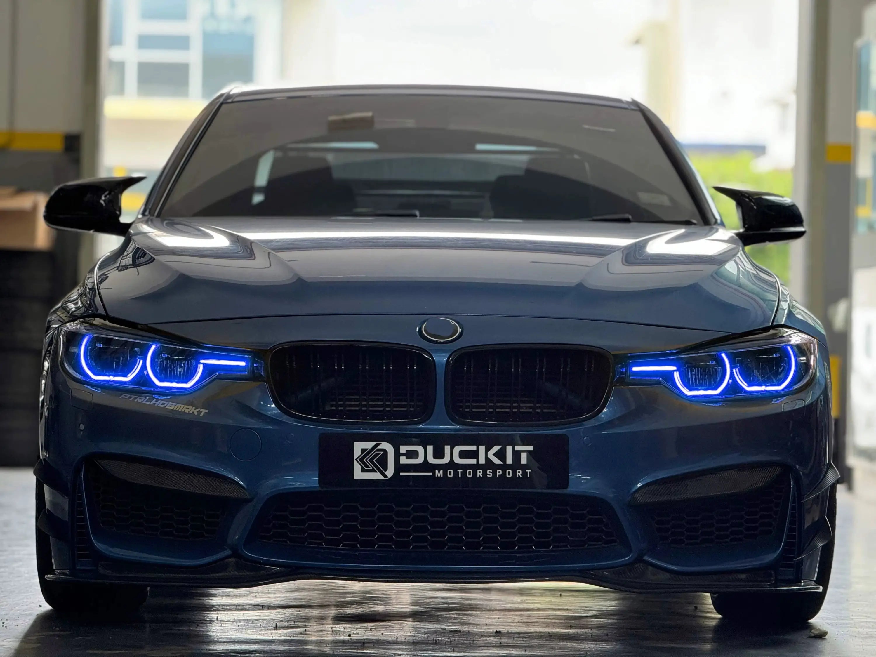 Sötétkék bmw m3 kipufogó rendszerrel és egyedi duckit motorsport karbon első lökhárítóval drl csl lámpa modullal