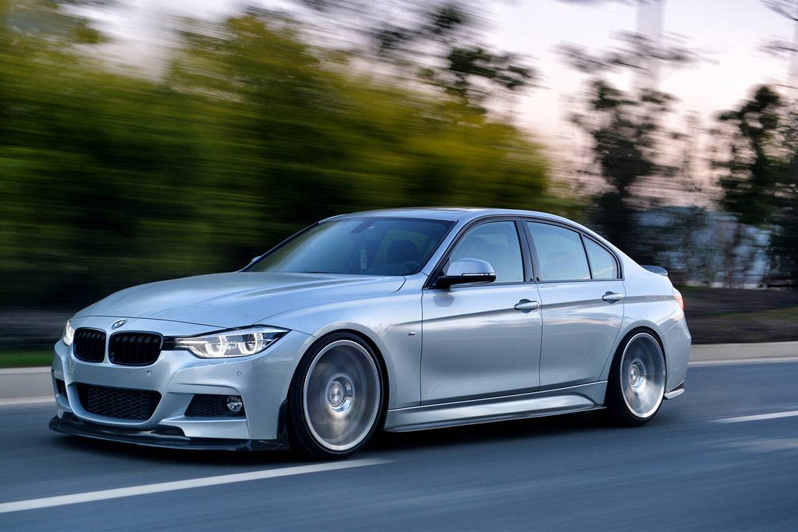 Mozgó ezüst BMW F30 első 3/4-es oldalnézetből, carbon első koptatóval (GV Style)