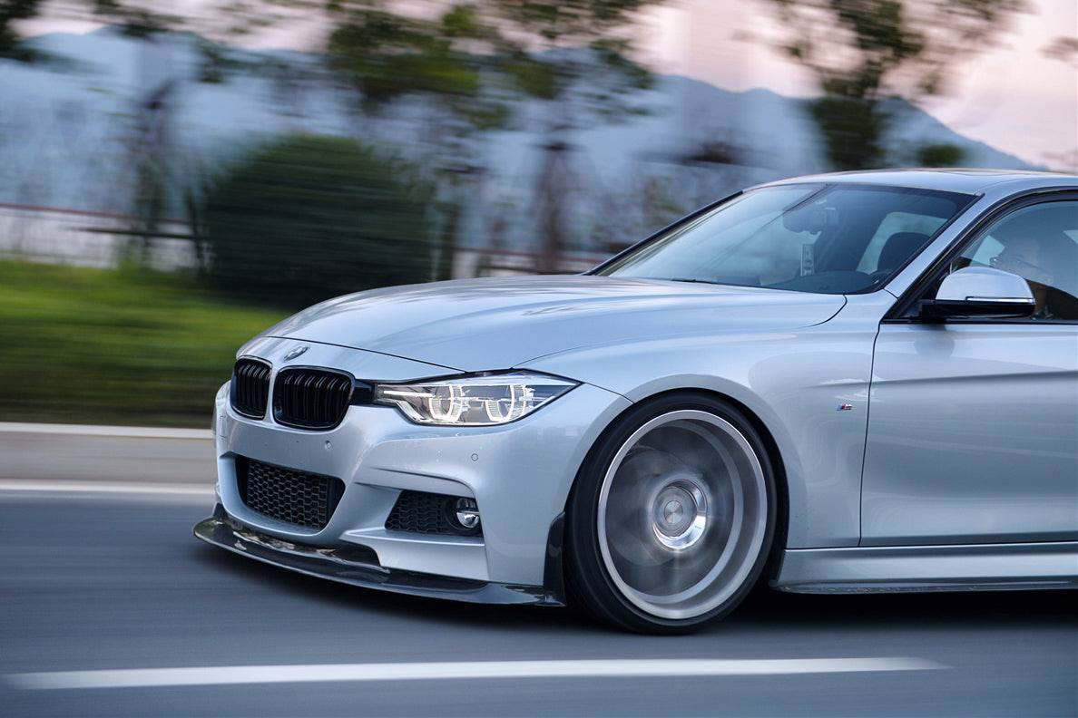 Ezüst BMW F30 elejének 3/4-es közelije menet közben, carbon első koptatóval (GV Style)