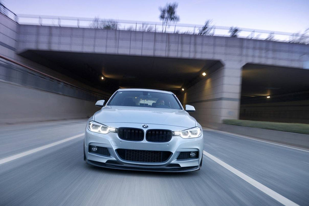 Ezüst BMW F30 LCI menet közben szemből, carbon koptató szett lip sarkokkal és beömlő borításokkal (GV Style)
