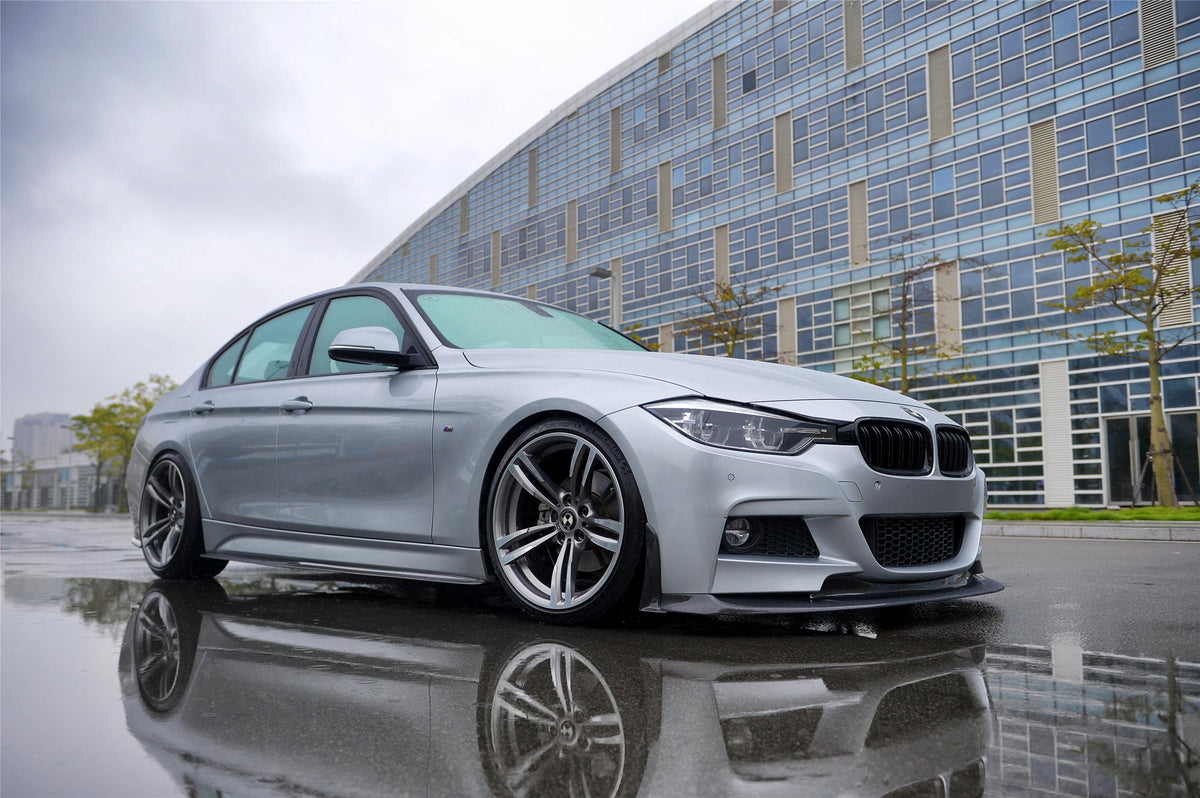 Ezüst BMW F30 alacsony első 3/4-es nézetből nedves aszfalton, carbon koptató szettel (GV Style)
