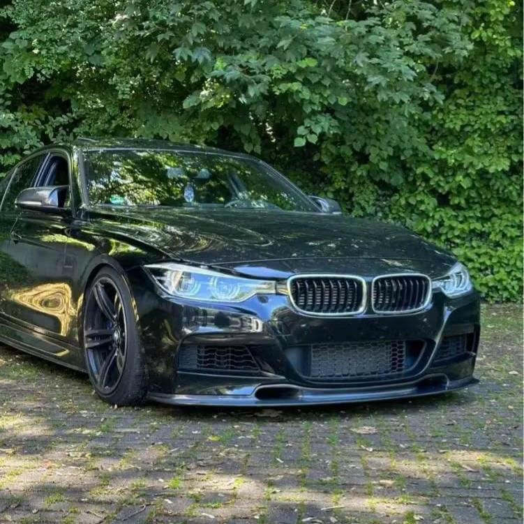 Fekete BMW F30 első 3/4-es nézetből, felszerelt carbon első koptatóval (Varis Style)