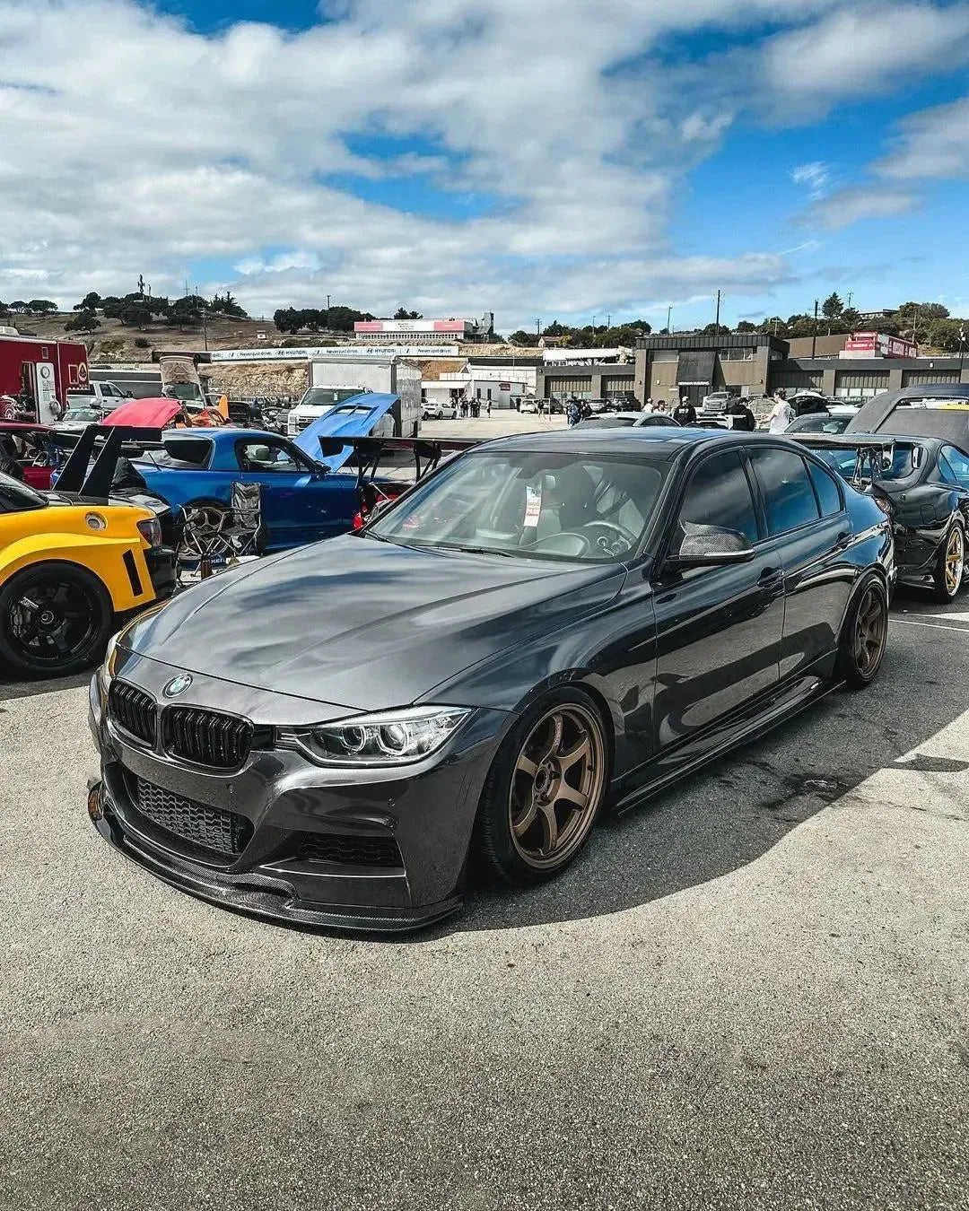 Szürke BMW F30 autós találkozón, első 3/4-es nézetből carbon első koptatóval (VRS Style)