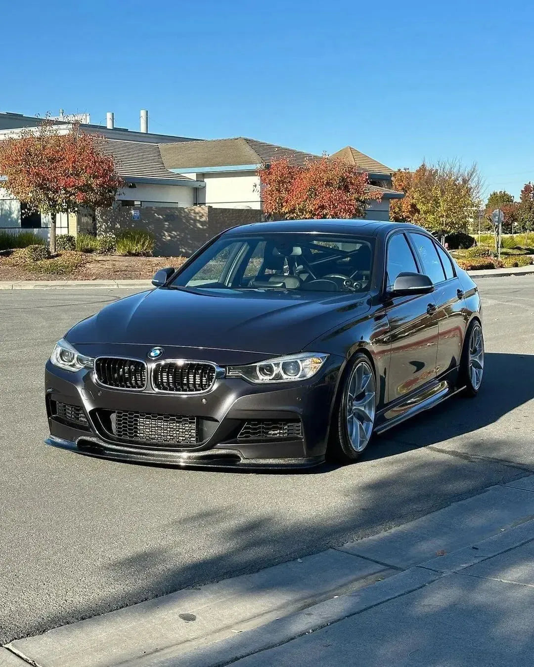 Sötétszürke BMW F30 az utcán, első 3/4-es nézetből, carbon első koptatóval (VRS Style)