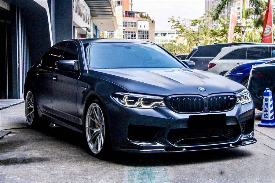 Matte dark gray pre-LCI BMW F90 M5 front three-quarter view, with carbon front lip (D3 Style)