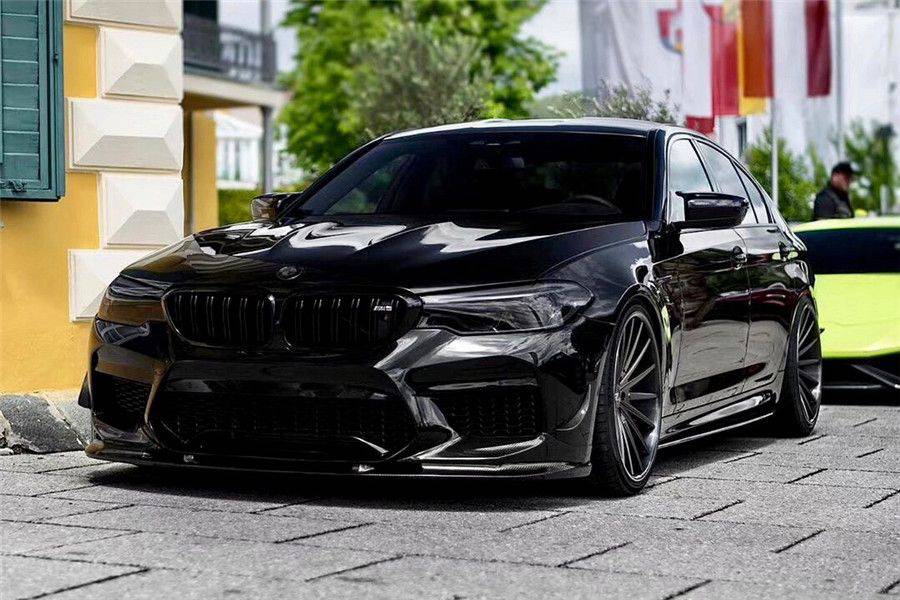 Black pre-LCI BMW F90 M5 left front three-quarter view, with fitted carbon front lip (D3 Style)