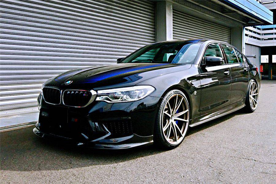 Black pre-LCI BMW F90 M5 from the left front, with carbon front lip and side skirts (D3 Style)