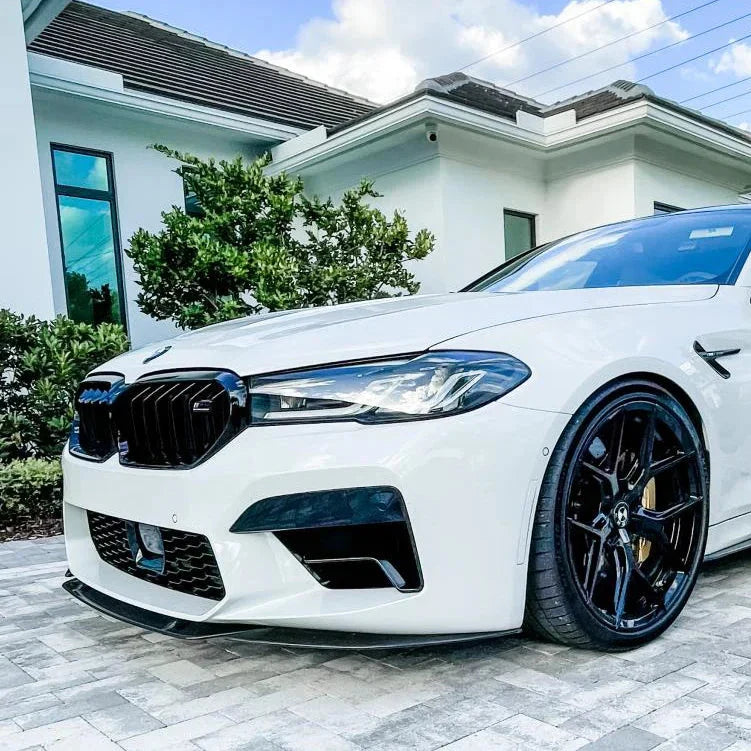 White BMW F90 M5 LCI front three-quarter view, with fitted carbon front lip (ST Style)
