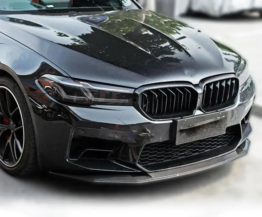 Black BMW F90 M5 front three-quarter close-up, with fitted carbon front lip (V Style)