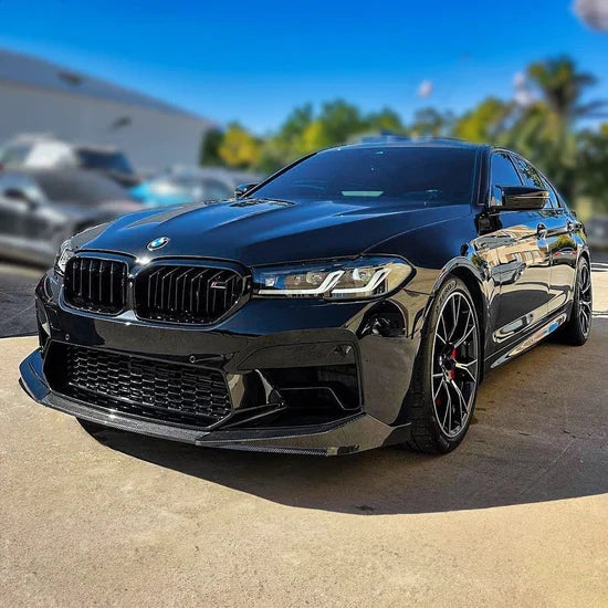 Black BMW F90 M5 LCI in a parking lot, front three-quarter shot with fitted carbon front lip (PM V1 Style)