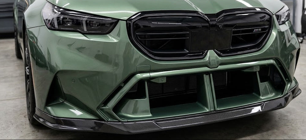 Close-up of a green BMW G90 M5 front bumper, with fitted carbon fiber front lip (Euro Style)