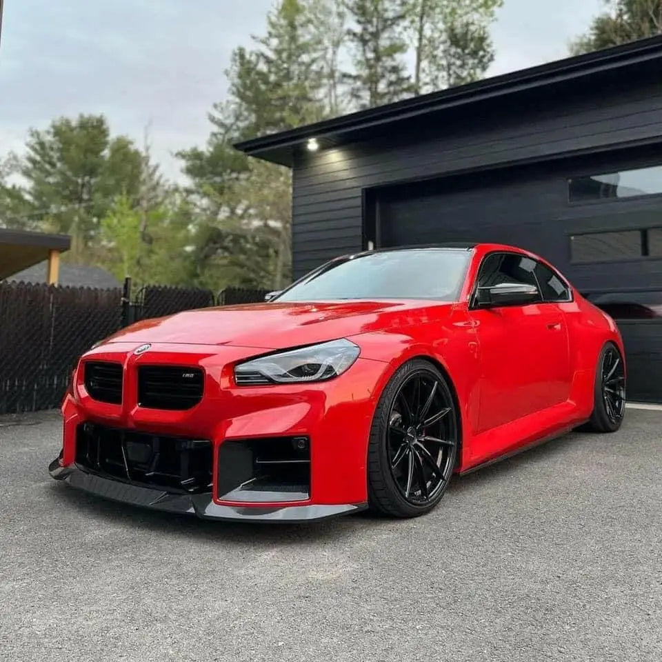 Vibráló piros bmw m2 fekete karbon szén első koptatóval, sportos megjelenésű kipufogó rendszerrel