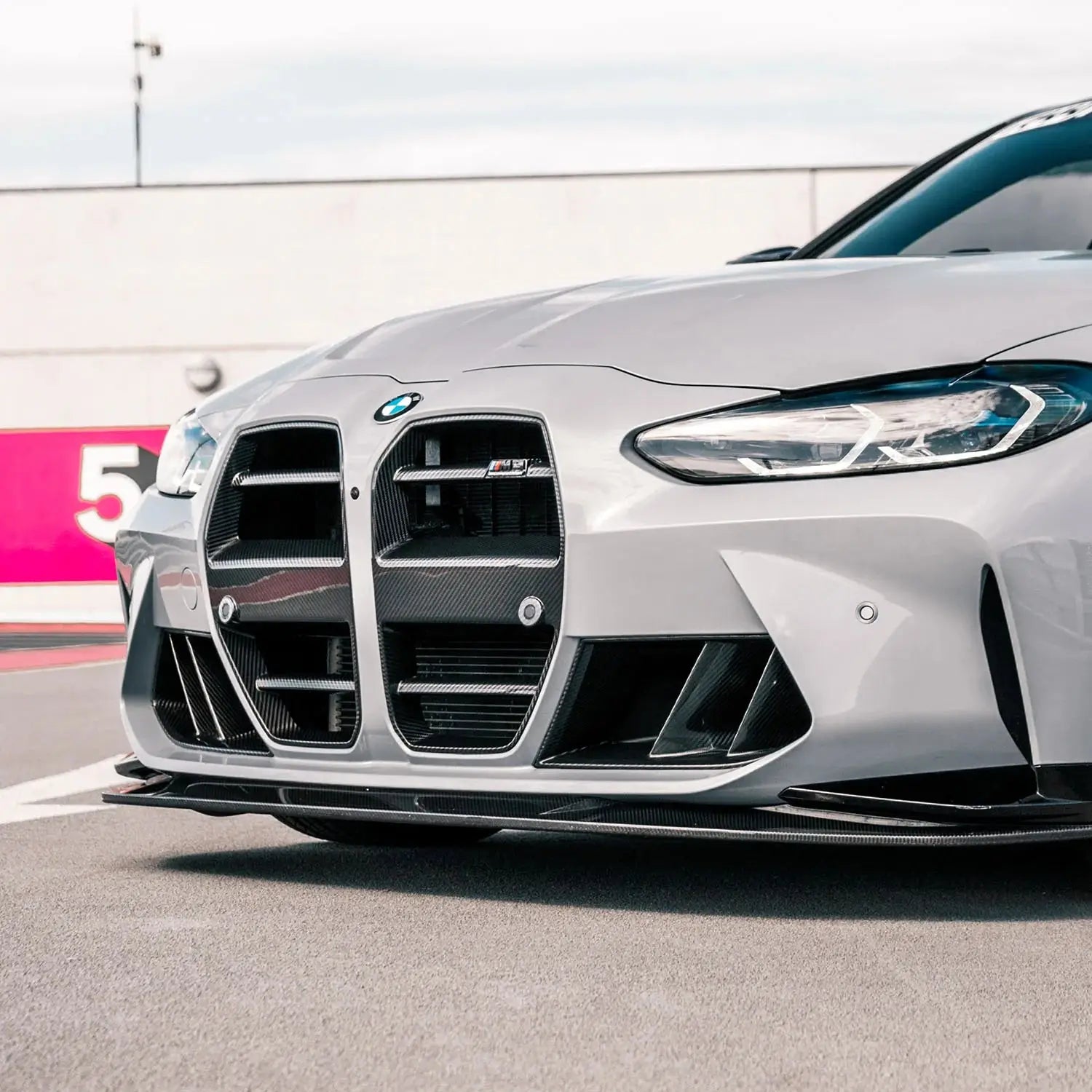 Ezüst bmw m3 első lökhárító karbon fiber vesével és agresszív aerodinamikai design kipufogó rendszerhez