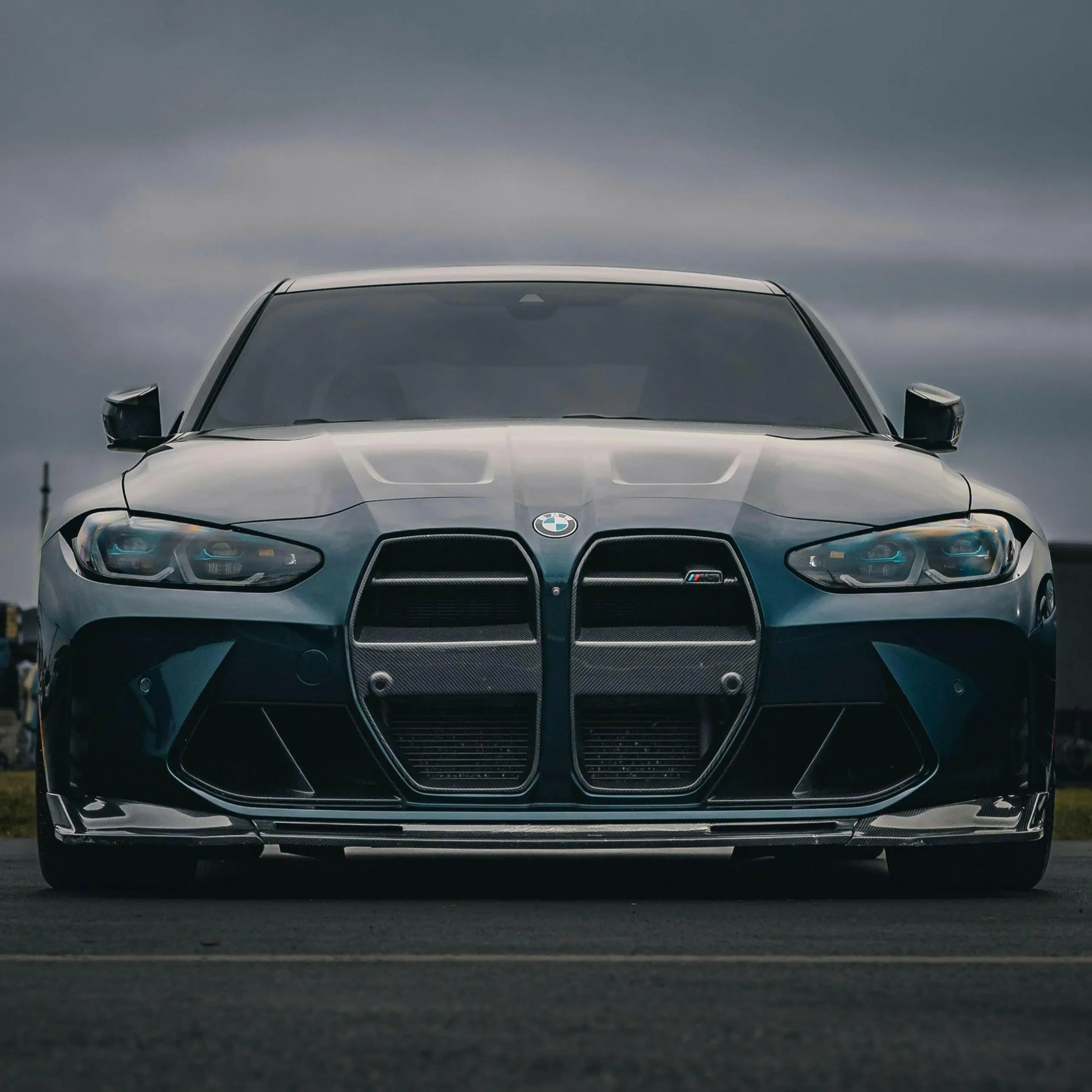 Sötét metálkék bmw m3 carbon fiber első lökhárító vese éles led fényszórókkal és agresszív kipufogó rendszerrel