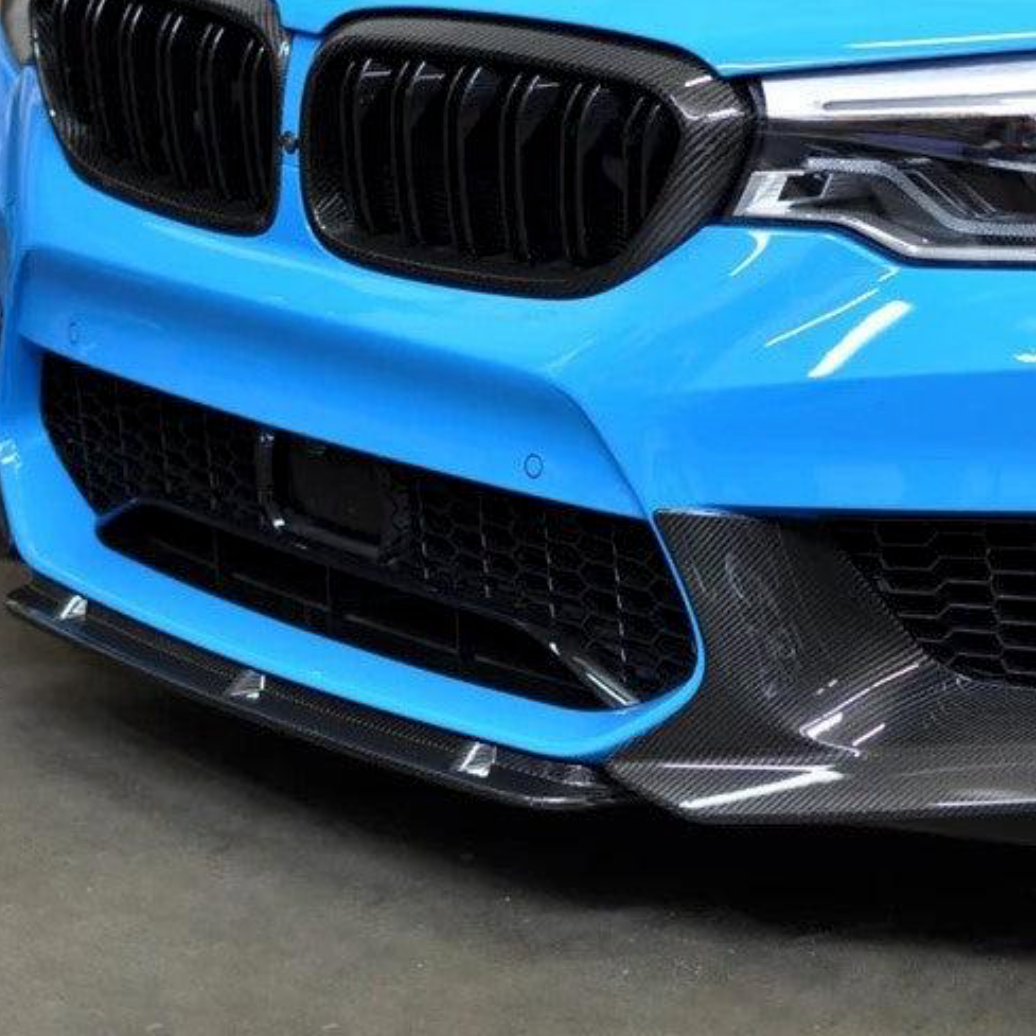 Világoskék pre-LCI BMW F90 M5 eleje közelről, felszerelt carbon lökhárító sarok díszléccel (PM Style)