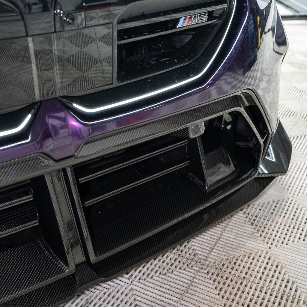 Close-up of a purple BMW G90 M5 lower front, with ribbed carbon fiber center trim (SQ Style)