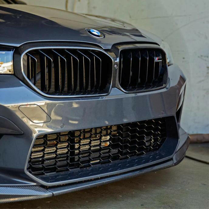 Szürke LCI BMW F90 M5 orra közelről, felszerelt carbon vesekeret-borítással