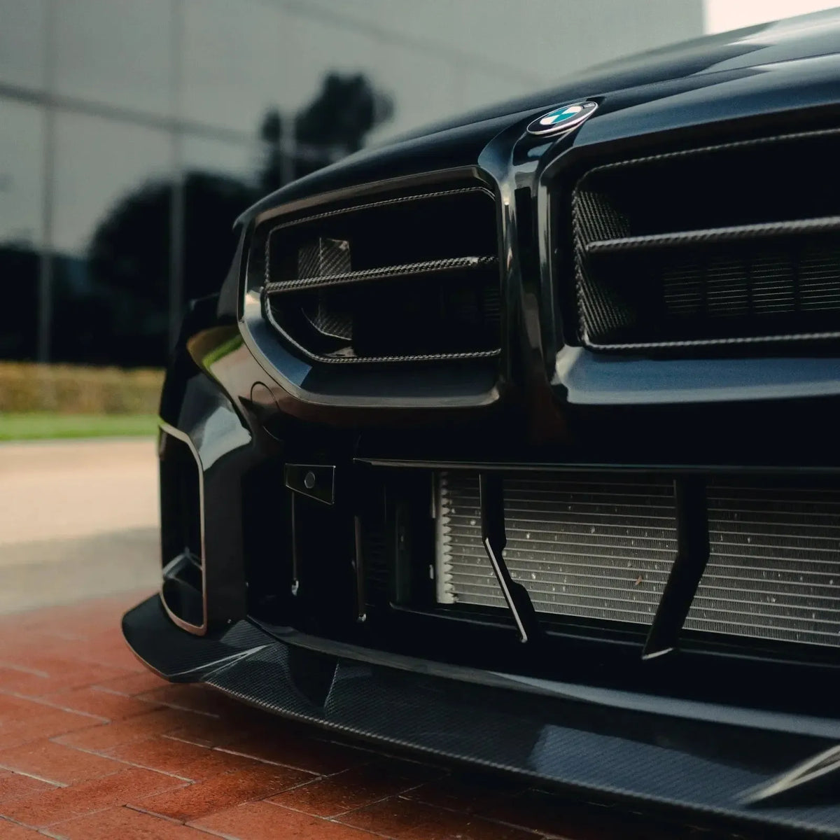 Black BMW G87 M2 carbon fiber front kidney grilles close-up (AN Style)