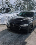 Fekete BMW F30 szedán első 3/4-es nézetből a hóban, felszerelt carbon motorháztetővel (GTS Style)