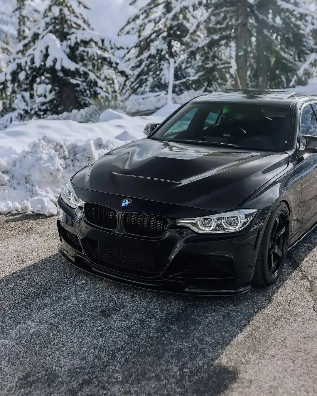 Fekete BMW F30 szedán első 3/4-es nézetből a hóban, felszerelt carbon motorháztetővel (GTS Style)