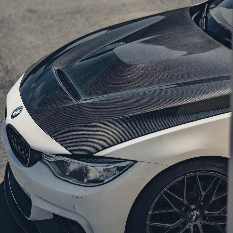 Fehér BMW F32 első sarka közelről, felszerelt kétoldalas carbon motorháztetővel (GTS Style)
