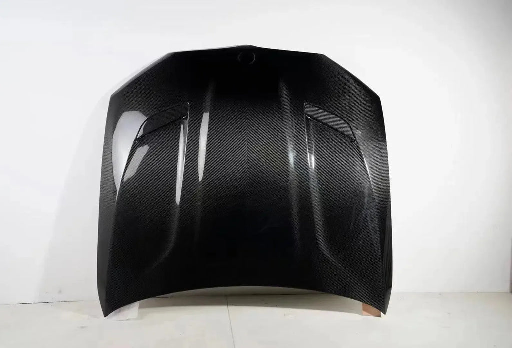 Carbon motorháztető két lamellás szellőzővel, felülről, fehér fal előtt (CS Style) – BMW F90 M5 és G30 5-ös sorozat