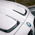 Fehér bmw m3 géptető karbon szálas kiegészítő elem fényes felülettel a kipufogó rendszerhez