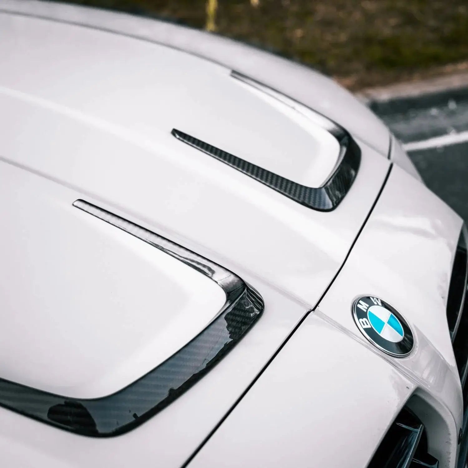 Fehér bmw m3 géptető karbon szálas kiegészítő elem fényes felülettel a kipufogó rendszerhez