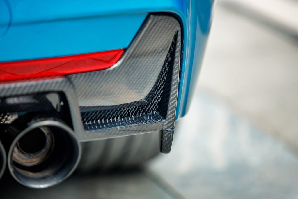 Close-up of the carbon diffuser's mesh-vented corner and exhaust tips on a blue BMW F32 (KB Style)