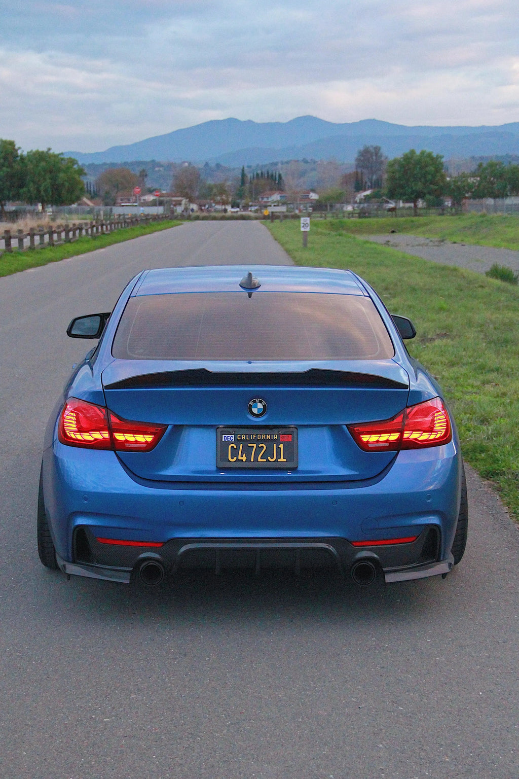 Blue BMW F32 from behind on the road, with carbon fiber rear diffuser (MP Style)