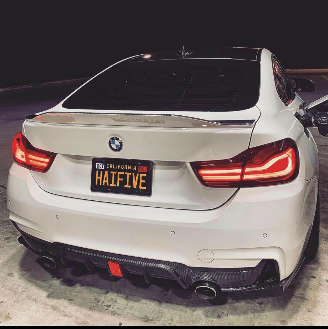 White BMW F32 coupé rear three-quarter view at night, with red LED brake light carbon diffuser (MP Style)