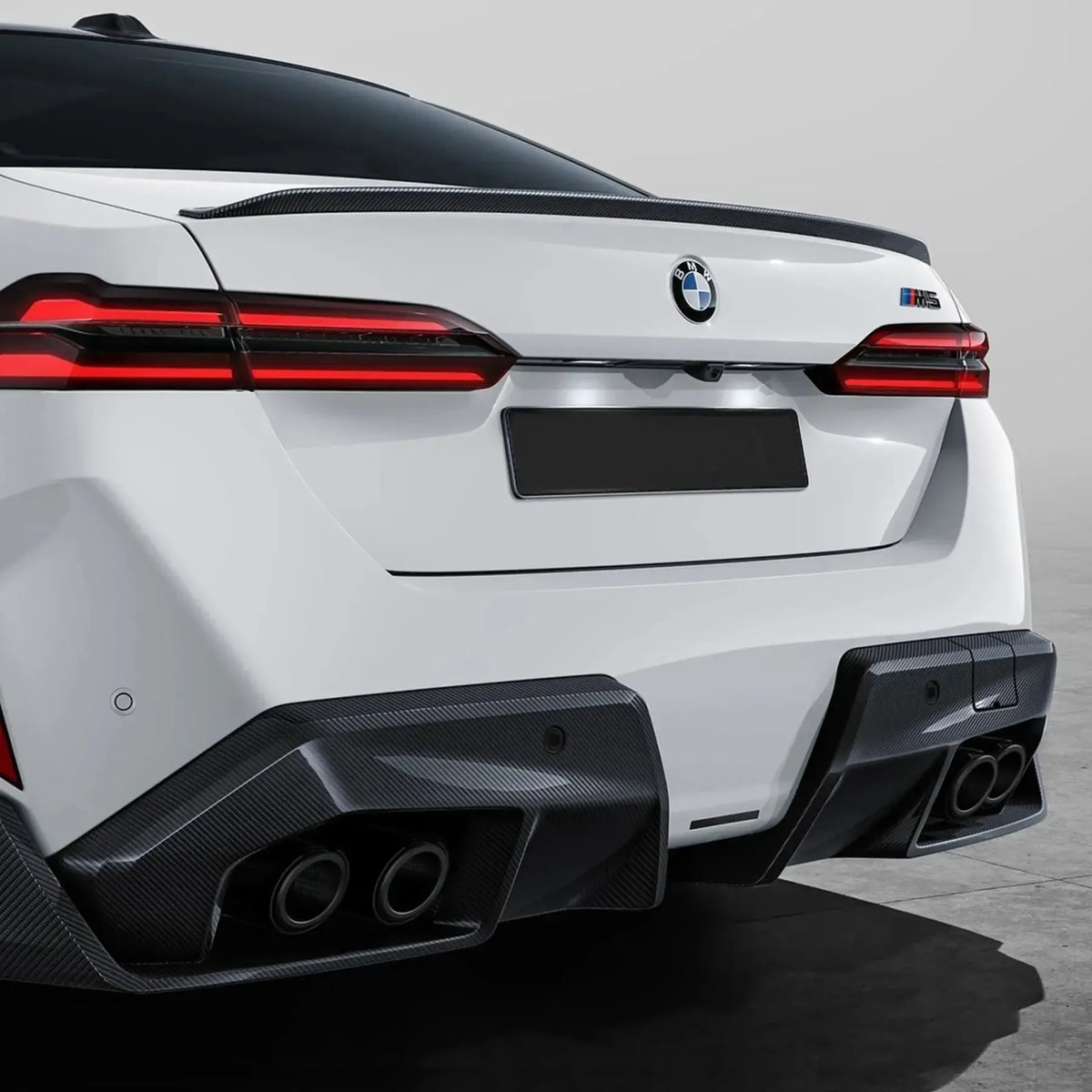 Fehér BMW G90 M5 hátulról 3/4 nézetben, felszerelt carbon fiber hátsó diffúzorral (MP Style)