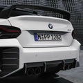 Hátsó diffúzorok carbon fiber bmw g87 m2 és fehér bmw m4 cs karbon spoilerrel és kipufogó rendszerrel hátulról