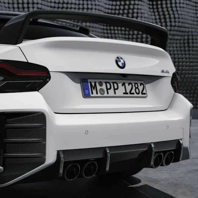 Hátsó diffúzorok carbon fiber bmw g87 m2 és fehér bmw m4 cs karbon spoilerrel és kipufogó rendszerrel hátulról