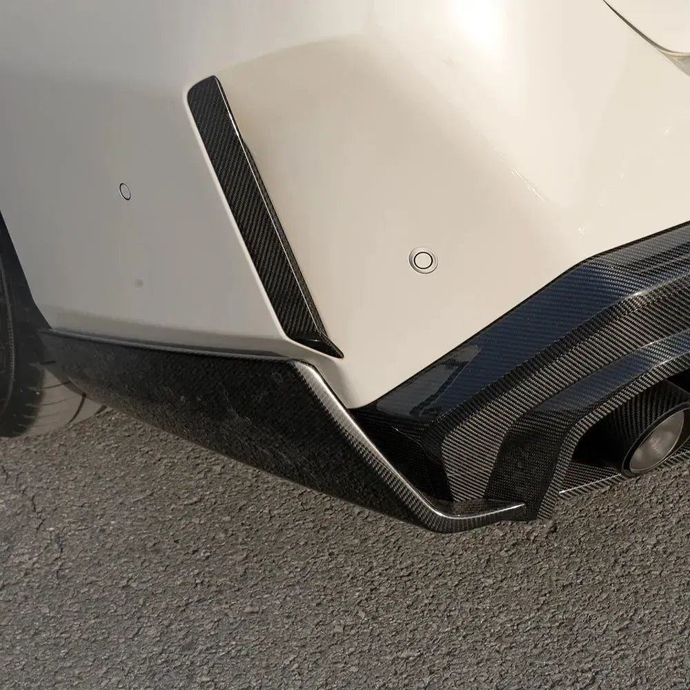 Carbon fiber prizma borítás a fehér BMW G90 M5 hátsó lökhárítóján, alacsony nézetből (SQ Style)