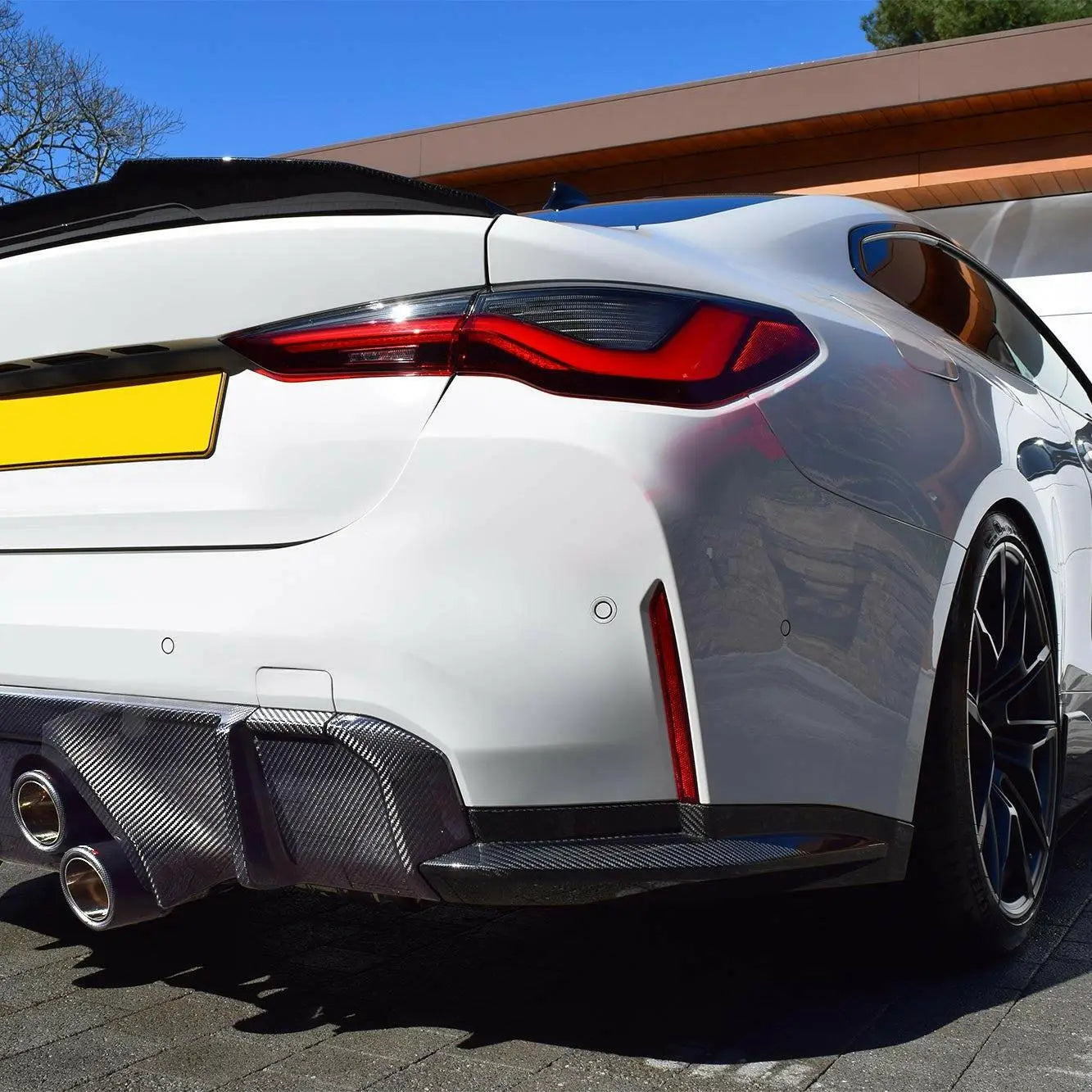 Hátsó szoknya carbon fiber bmw g80/g81 m3 és g82/g83 m4 fehér karbon kipufogó rendszerrel és bmw m3 kipufogóval hátulról