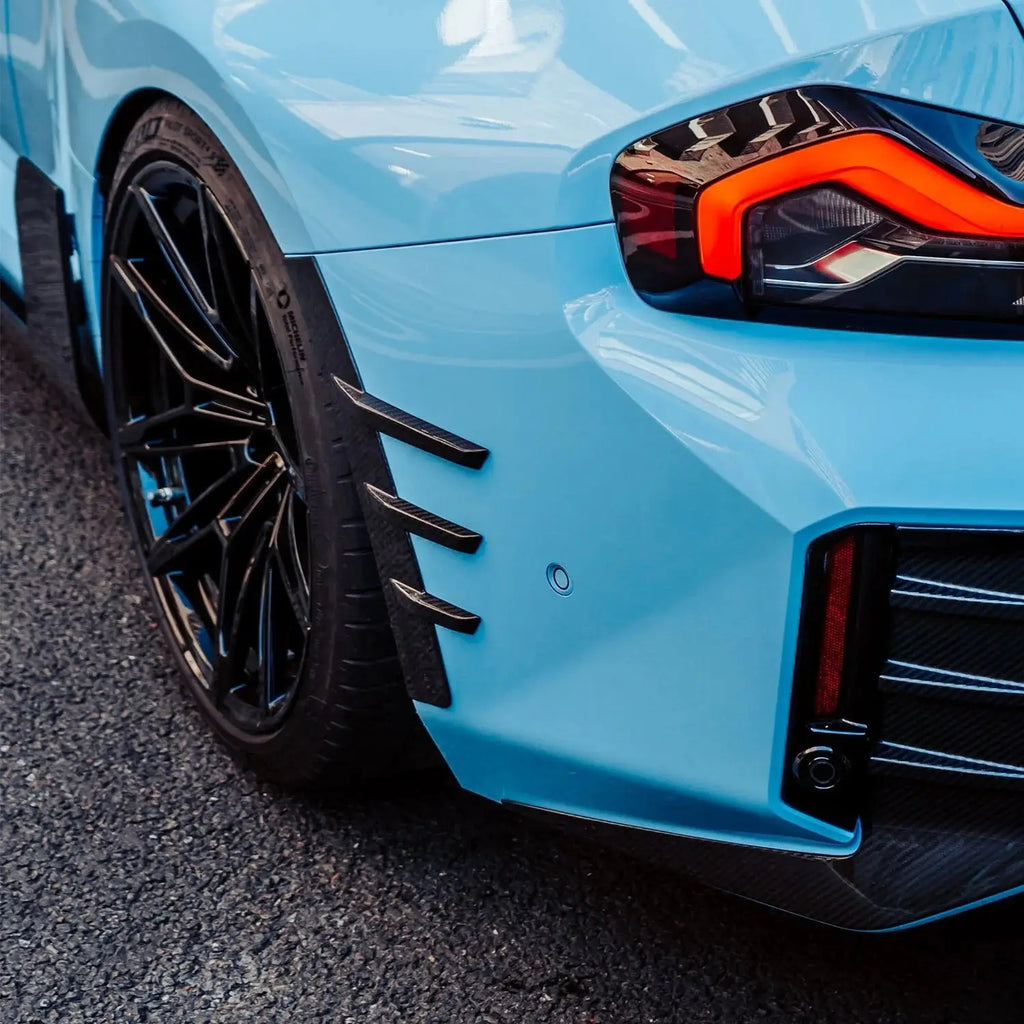 Light kék bmw m4 fekete carbon fiber kárpitokkal és sportos kipufogó rendszerrel kerékív sárvédő betét g87 m2-hez