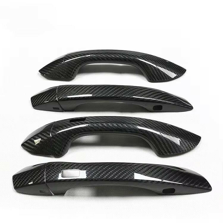Four stacked carbon door handle covers, side view, on a white background – Audi RS6 Avant C8