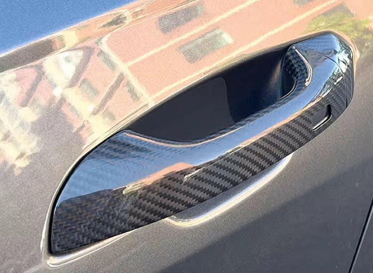 Close-up of a gray car door with fitted carbon door handle cover – Audi RS6 Avant C8