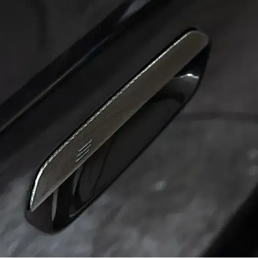 Sötét színű BMW G90 M5 kilincse átlósan fotózva, carbon borítással